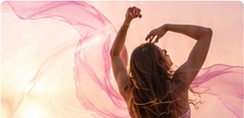 Mujer bailando de espaldas entre telas rosas